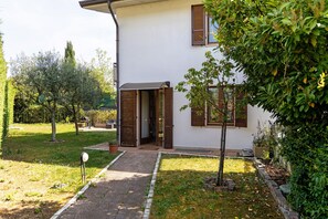 Una casa moderna con acceso pavimentado, un pequeño jardín y un buzón.