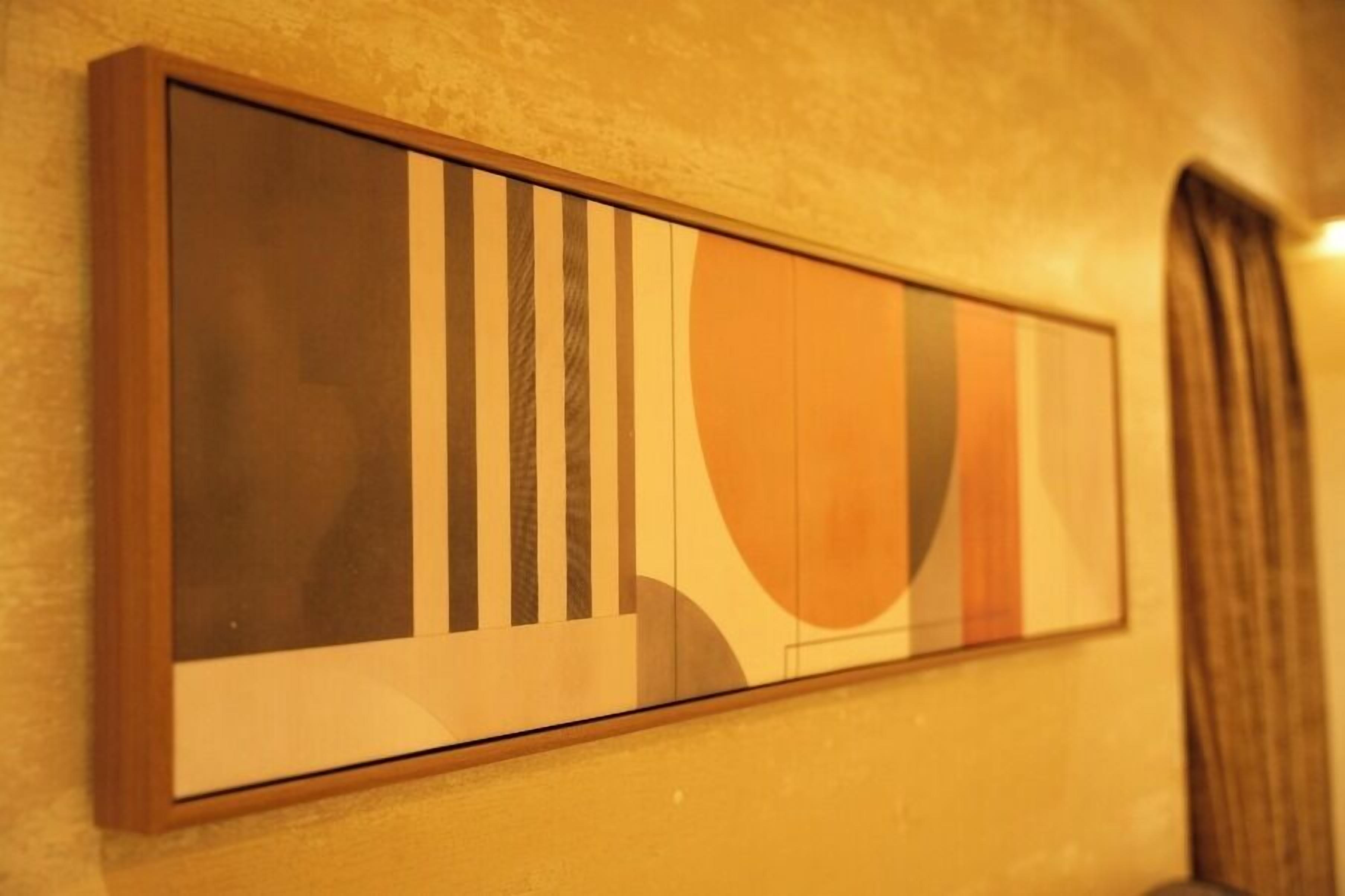 A framed abstract artwork on a wall.