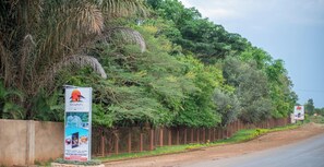 Un letrero de Nalipiri Eco Resort con una cerca y follaje al fondo.