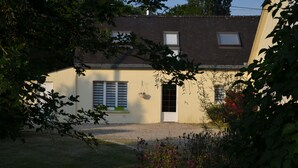 A house with a sloped roof, a front door, and a window with shutters. - LA PETITE MAISON DE KERTHOMAS - CLASS 3* GÎTE (plumergat)
