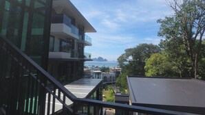 Un edificio moderno con fachada de vidrio, una escalera y vista al mar y a islas distantes.