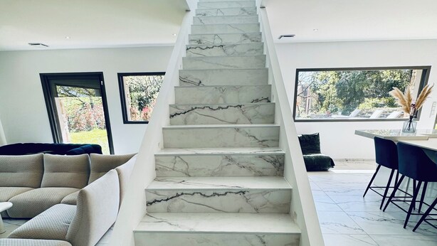 Eine Treppe mit Marmorstufen, die zu einer oberen Ebene führt.