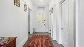 Ein Flur mit weißen Wänden, einem gemusterten Teppich und einer Tür mit Fenster.