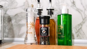 Un taulell de cuina amb diferents condiments i un salzet.
