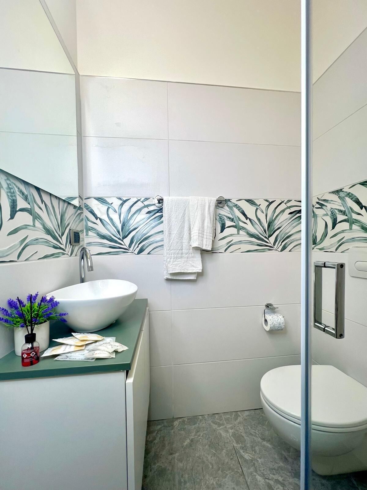 Un baño con lavamanos blanco, inodoro y zona de ducha.