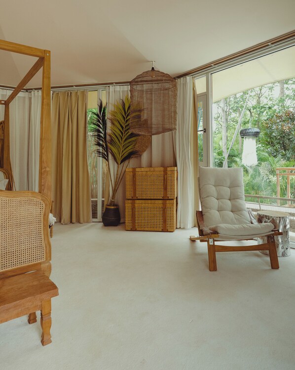 A room with a large window, a wicker chair, a rattan sofa, and a hanging light fixture. - ELIVAAS Privé Bali Bay Exclusive Resort (Gauribidanur)