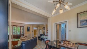 A spacious living area with a sofa, dining table, and chairs, a chessboard, and a ceiling fan. - Exclusive villa with view, garden, bbq, pets allowed and parking space (Montefalco)