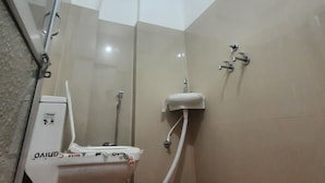 A bathroom with a toilet, a sink, and a shower. - Hotel Aditya Bikaner (Bikaner)