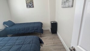 Ein Schlafzimmer mit zwei Betten, einer Tür und einem kleinen Lautsprecher.