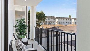 A balcony with a view of a courtyard and buildings. - Spacious 4-bedroom townhome in beautiful Hawthorne with AC (Hawthorne)