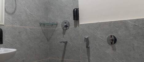 A modern bathroom with a toilet, bidet, and shower.