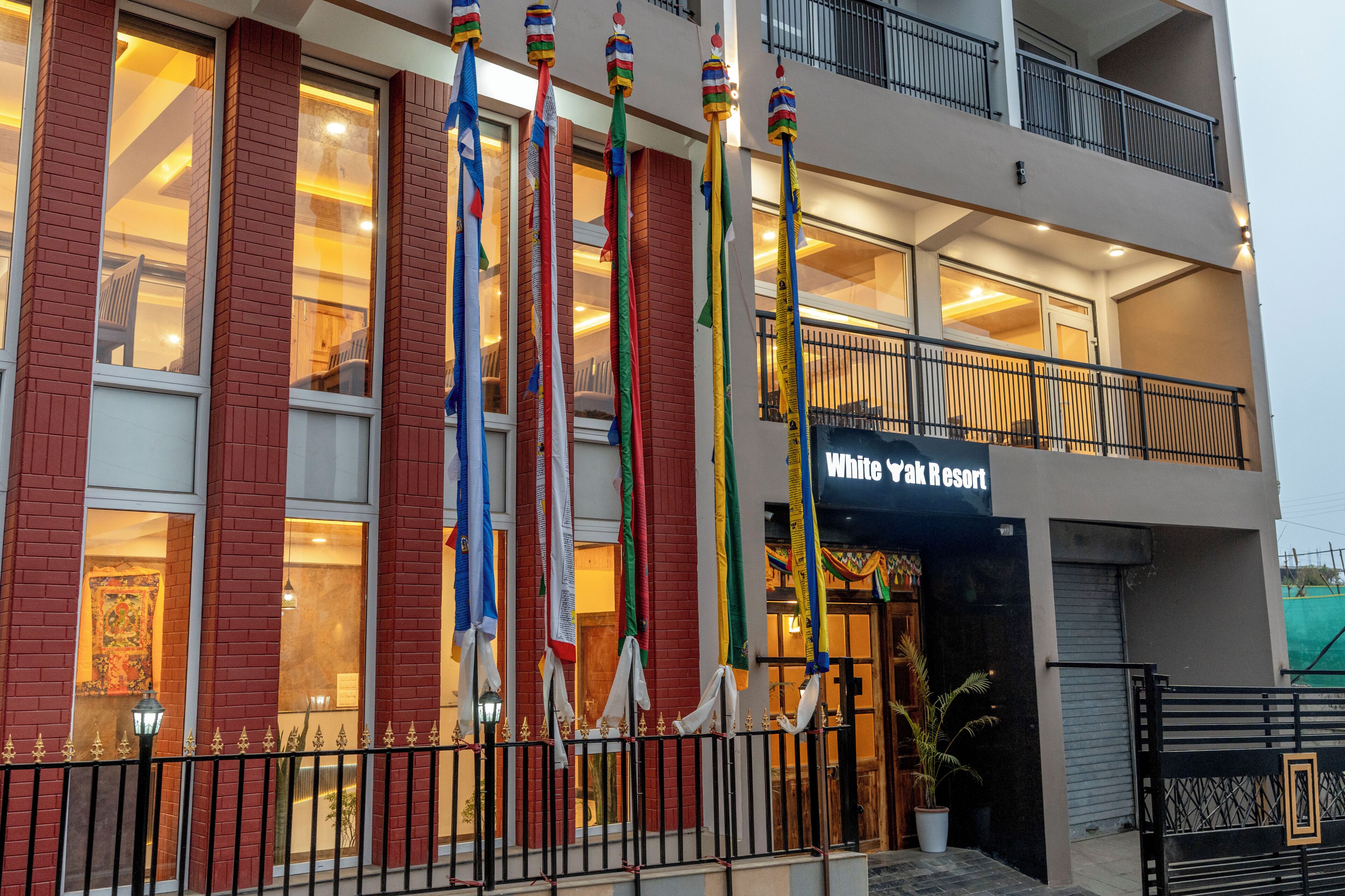 A building with multiple windows, a balcony, and flags.