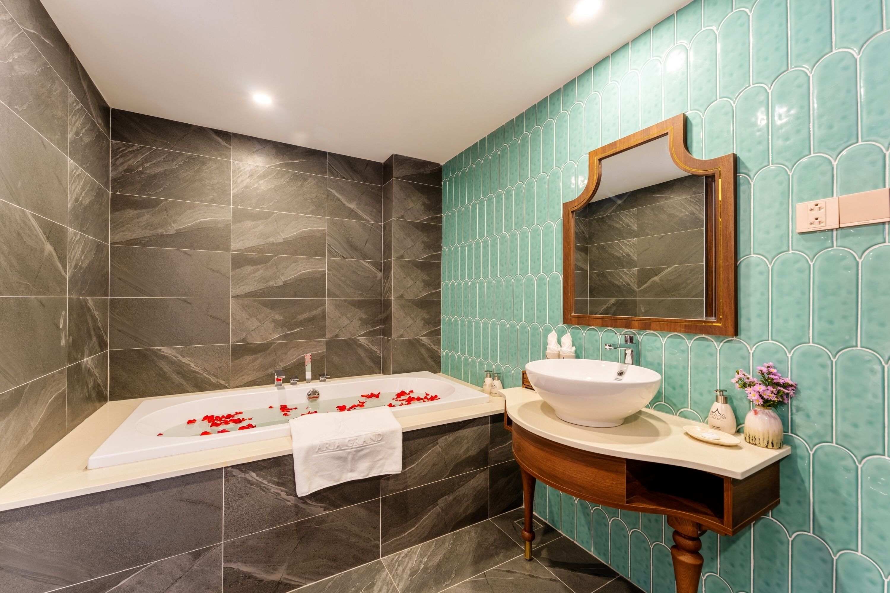 A bathroom with a bathtub, a sink, and a mirror.