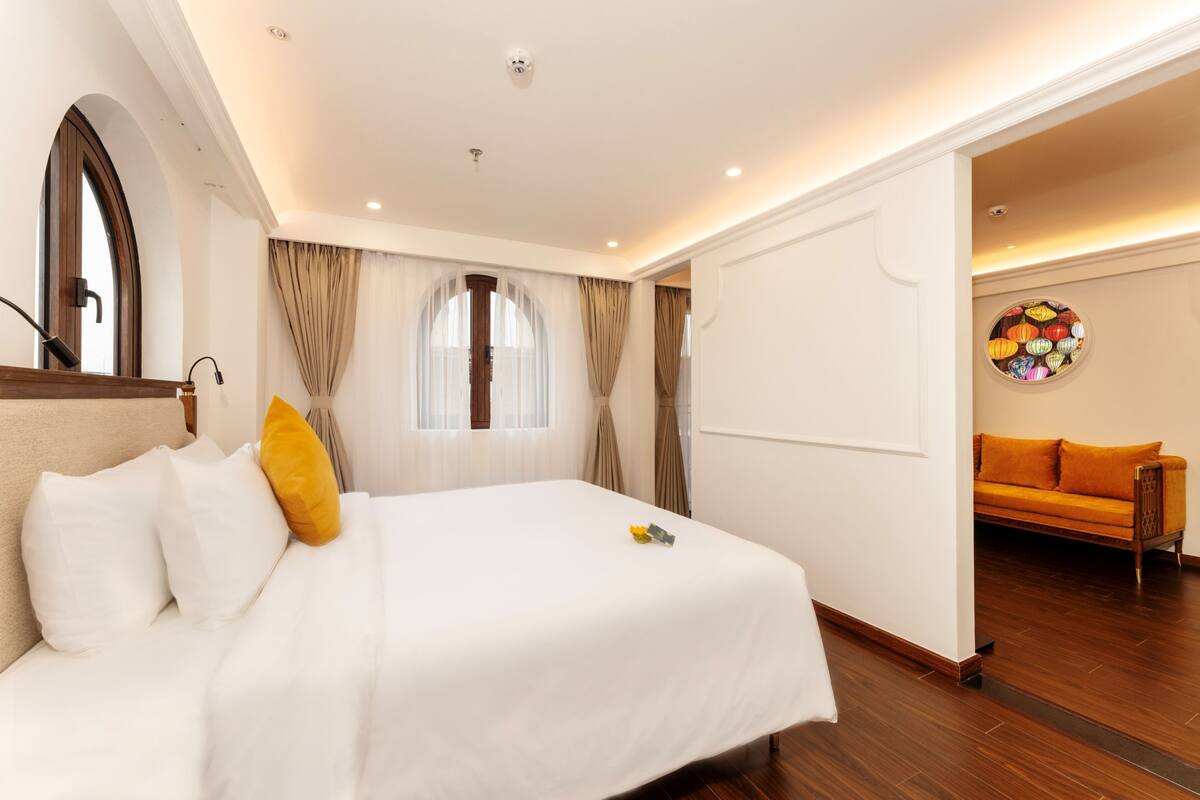 Een hotelkamer met een bed, een slaapbank en een muur met een decoratieve cirkel.