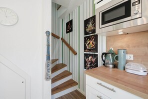 A kitchen with a microwave, kettle, and coffee maker on the counter. - Platzhirsch - New Platzhirsch vacation apartment in Greetsiel for relaxation (Krummhörn)