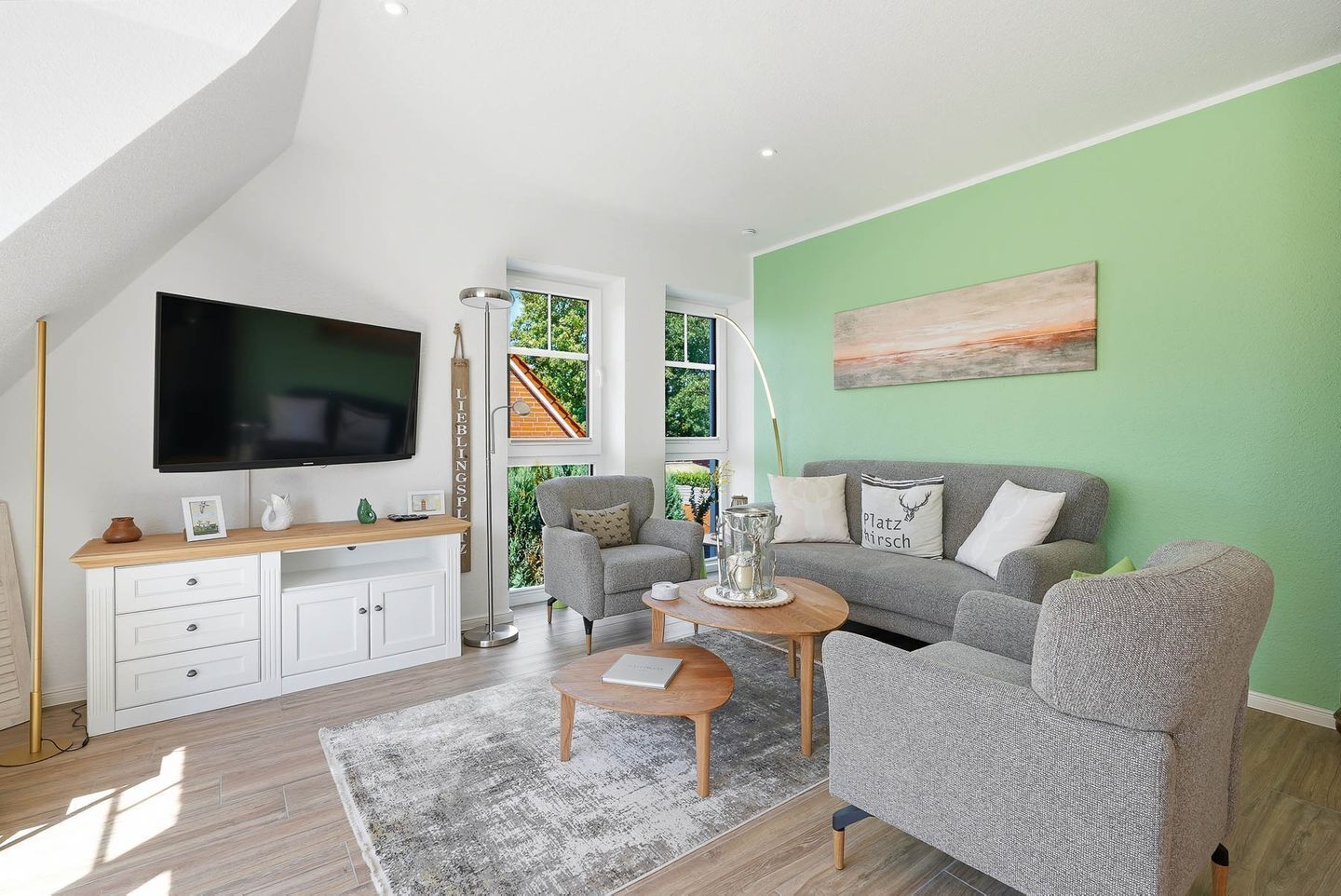 A modern living room with a television, sofa, and coffee table.