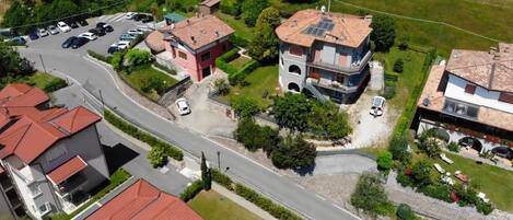 A residential area with houses, a road, and parked cars.
