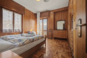 Ein Zimmer mit einem Bett, einem Holzschrank und einem Spiegel.
