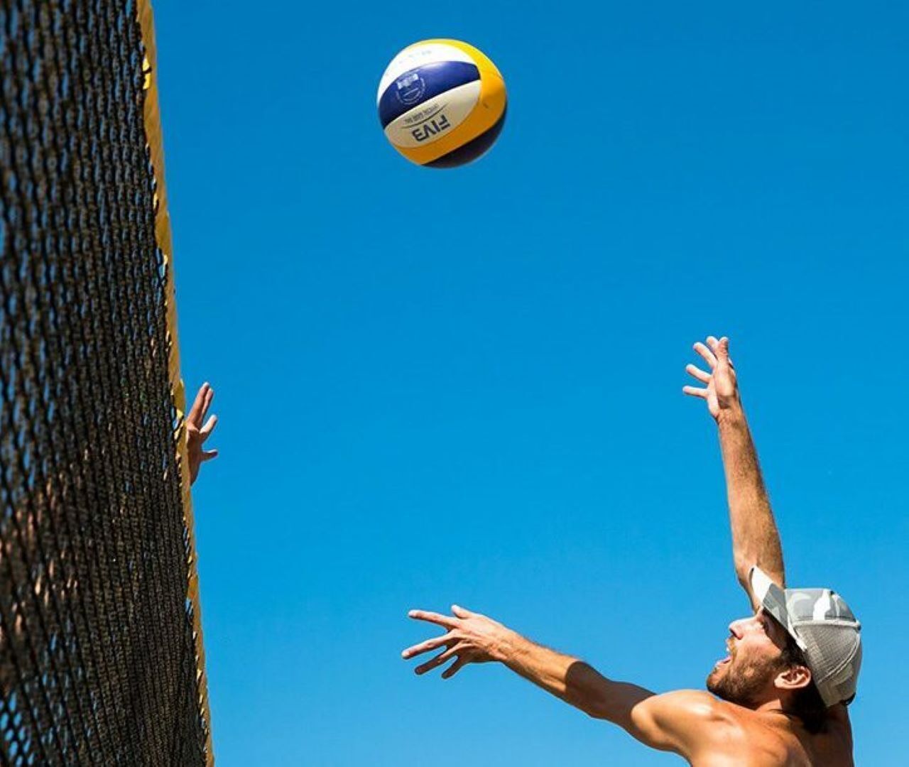 Une personne qui tend le bras pour frapper un ballon de volley-ball.