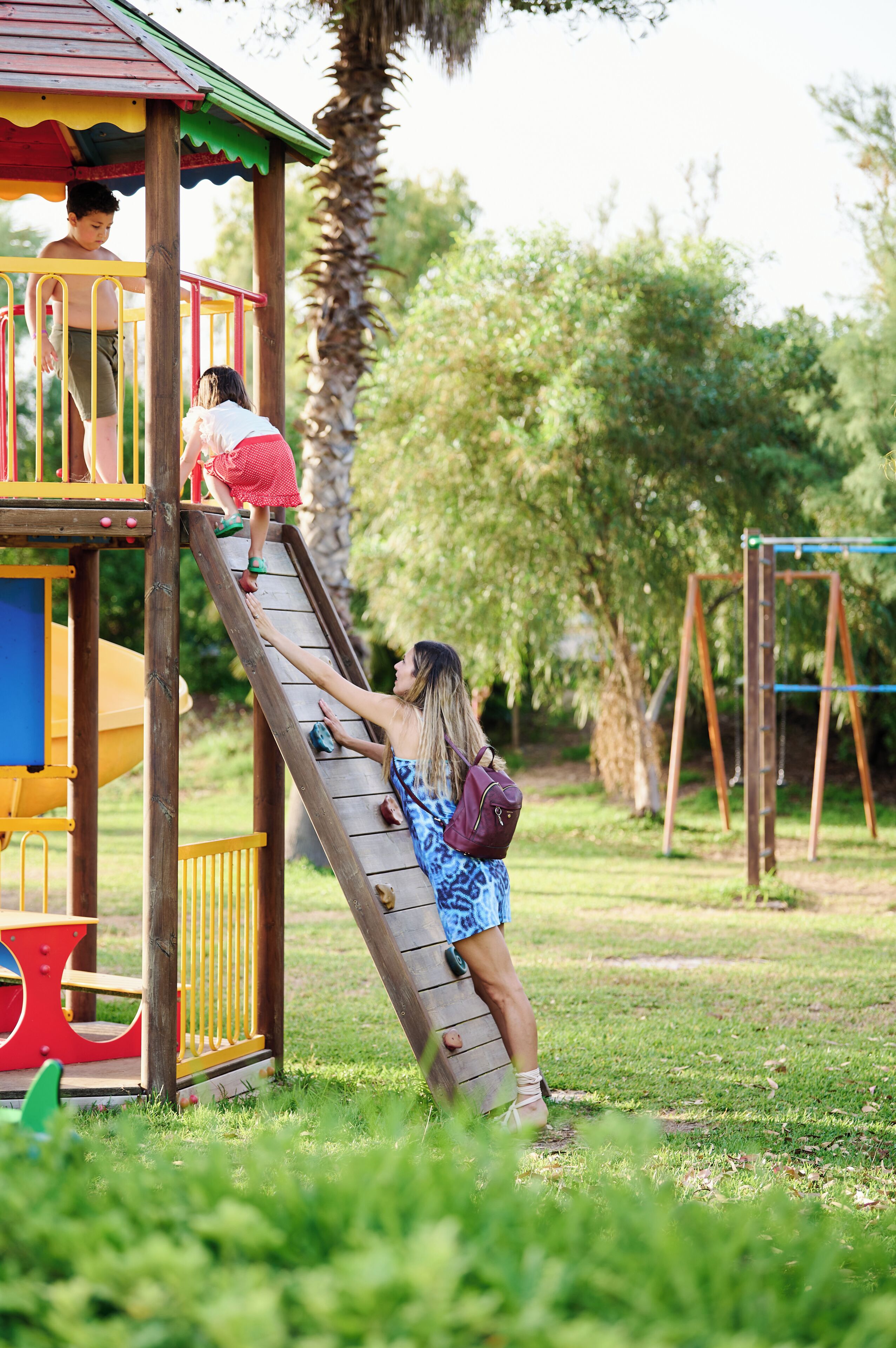 A playground with a slide, climbing area, and swings.