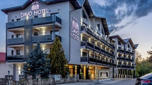 A multi-story hotel with balconies, a prominent sign, and a well-lit facade. - Davo Hotel (Târgu Neamț)