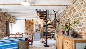 Un intérieur chaleureux avec un escalier en colimaçon, un coin repas et une cuisine.