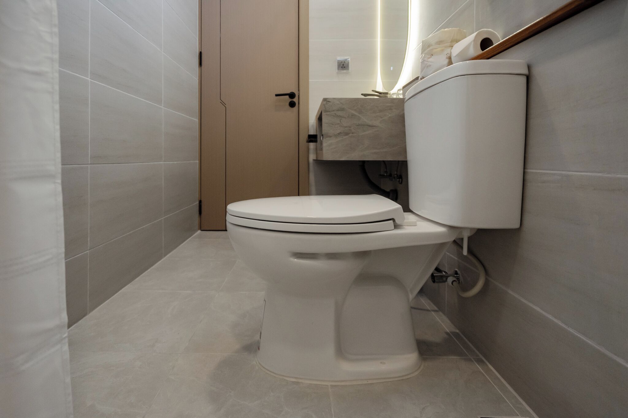 A modern bathroom with a toilet, a sink, and a shower area.