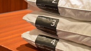 Four pillows stacked on a wooden surface, each with a black label indicating a number.