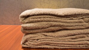 A stack of folded towels on a wooden surface.