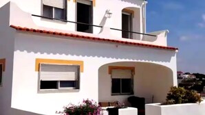 A two-story building with a white facade, red-tiled roof, and a small balcony. - Oceanfront house in Benagil (Lagoa)