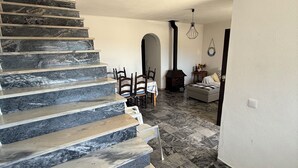 A staircase with alternating marble and wood steps leading to a dining area with a table and chairs. - Oceanfront house in Benagil (Lagoa)