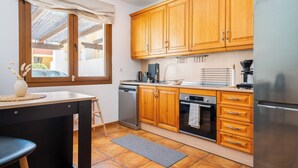 A kitchen with wooden cabinets, a dishwasher, an oven, and a refrigerator. - Spacious 4BR Townhouse - Rooftop Terrace (Fuengirola)