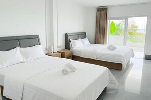 Two beds with white linens, a nightstand, a window with a view, and a curtain. - GUI ZHI HOTEL Koh Rong (Koh Rong)