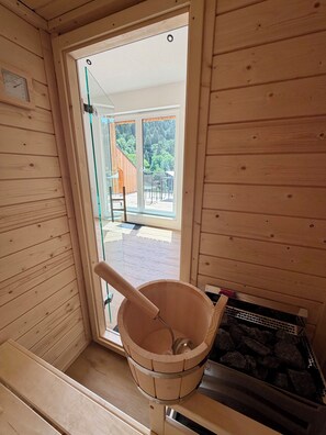 A wooden sauna room with a wooden bucket and a sauna bench. - Moonlight Soul (Triberg) - Loggia and sauna (Triberg im Schwarzwald)