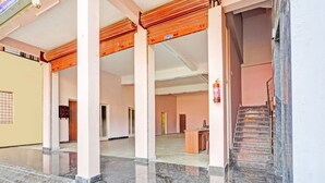 A hotel lobby with a marble floor, a staircase, and a reception desk. - Hotel O Ramarvapadu Near ESI Hospital (Penumuluru)