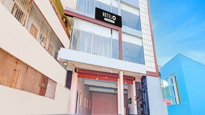 A modern hotel with a prominent sign, a covered entrance, and a clear sky. - Hotel O Ramarvapadu Near ESI Hospital (Penumuluru)
