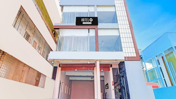 A modern hotel building with a sign reading 'HOTEL' and a company service logo. - Hotel O Ramarvapadu Near ESI Hospital (Penumuluru)