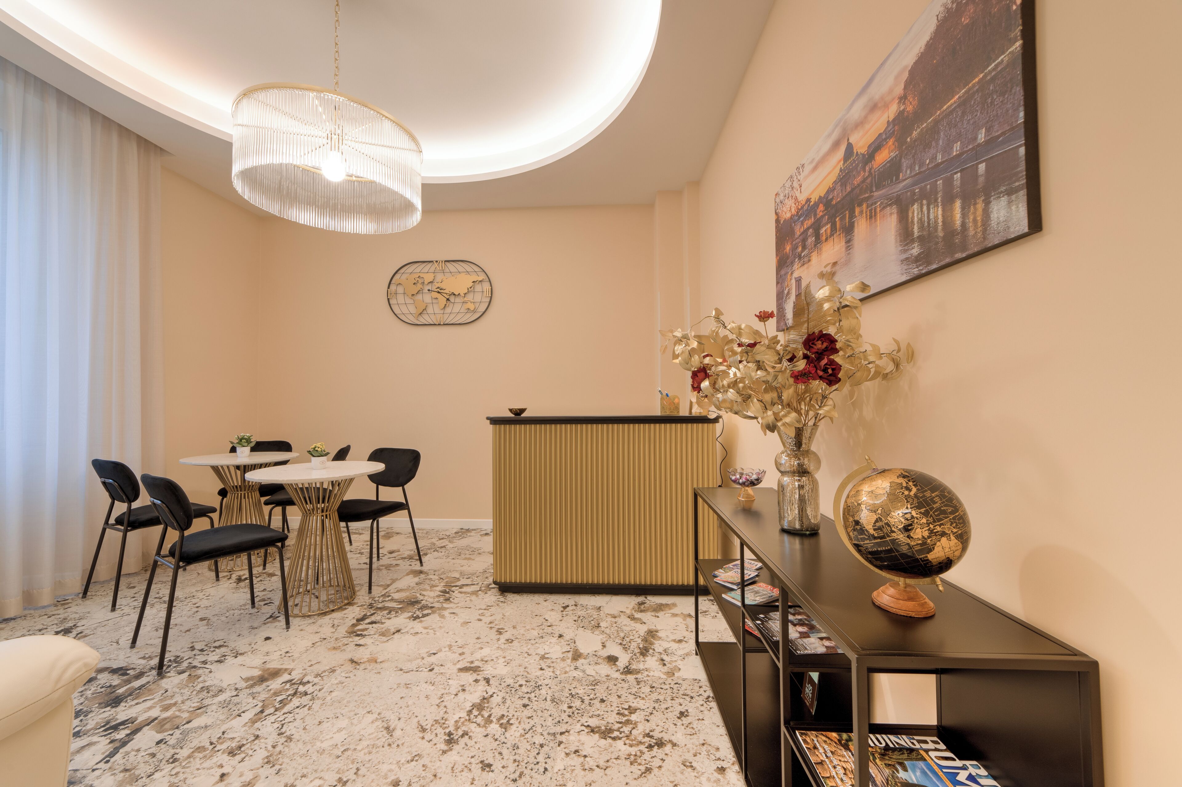 A hotel lobby with a round table, chairs, a reception desk, a globe, and a world map on the wall.
