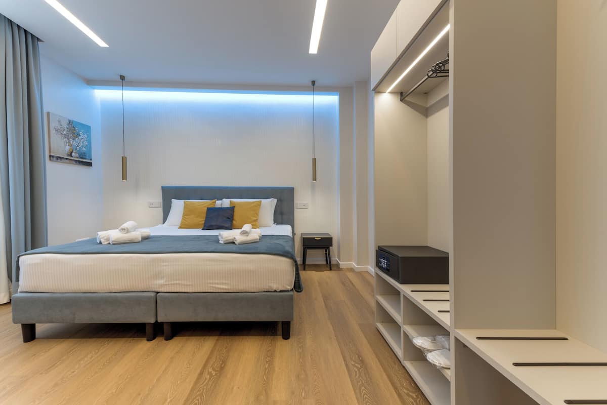 A modern bedroom with a bed, bedside tables, and built-in storage.