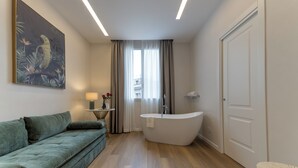 A modern bathroom with a freestanding bathtub, a toilet, and a sink. - GH Villa Poerio (Rome)
