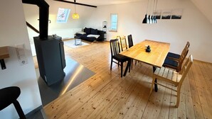 Un intérieur moderne comprenant un coin repas, un canapé, une cheminée et un escalier.