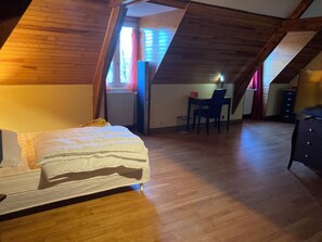 A room with a bed, a desk, and a chair.