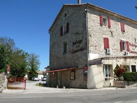Um edifício de pedra com placa indicando Auberge de Couronne, um restaurante e um hotel.