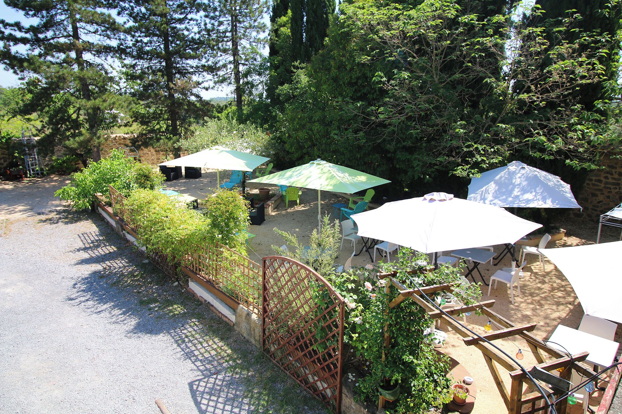A patio area with outdoor seating, a wooden fence, and greenery.