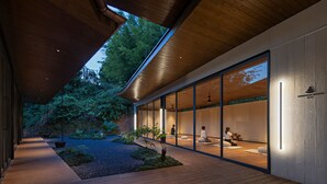 A modern building with a wooden exterior, large glass windows, and a view of a forested area. - SINYE IN THE VALLEY (Guangzhou)