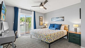 A hotel room with a bed, desk, computer, and a view of the water. - Lake Mode Lakefront Balcony (Osage Beach)