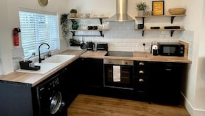 Una cocina moderna equipada con lavavajillas, horno, microondas y fregadero.