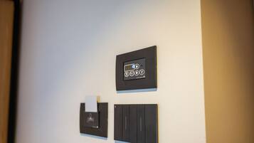 Una pared con tres paneles de control, uno con una pantalla digital y dos con botones.