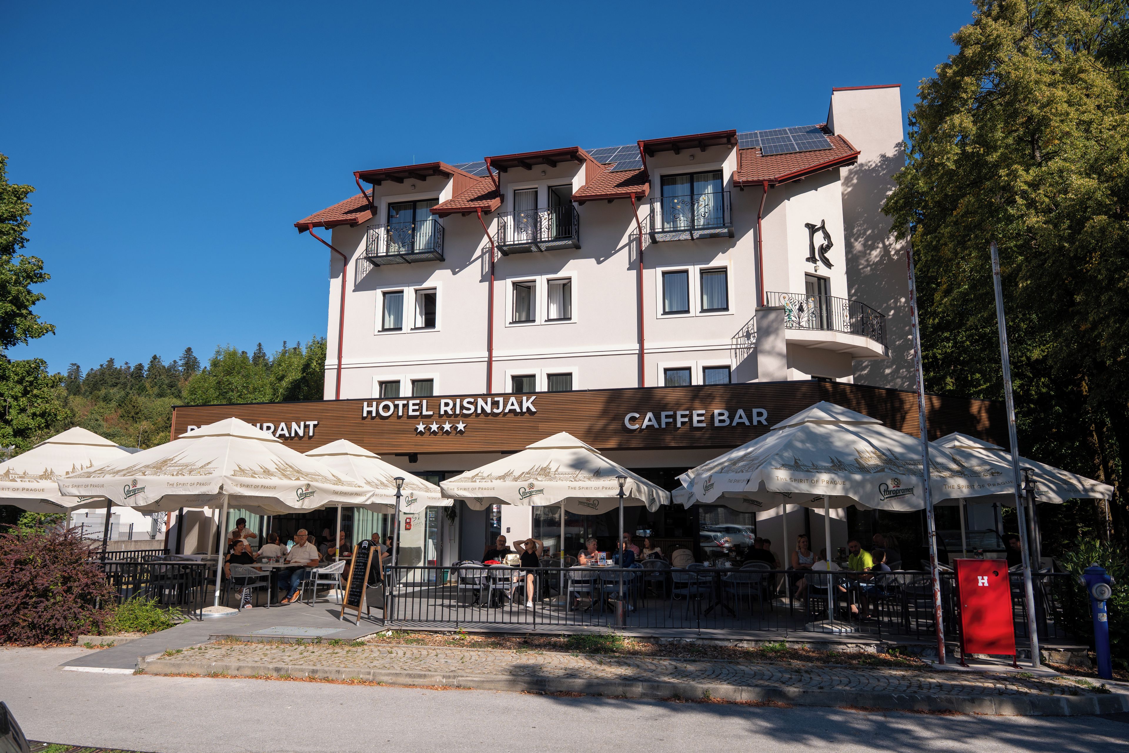 Ein Hotel mit Außenbestuhlung und einer Café-Bar.