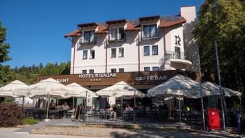 Un hotel con terraza y un bar cafetería.